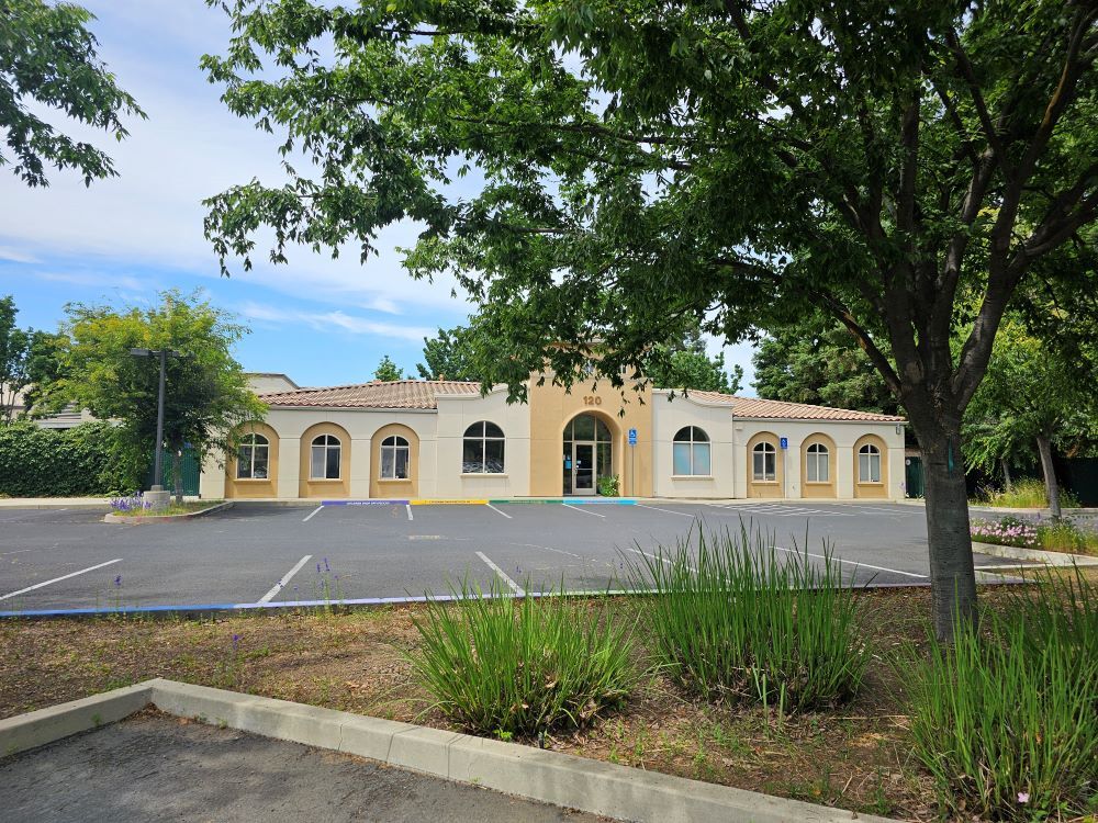 A picture of the exterior of Enchanted Play Preschool Center with a parking lot in the foreground.